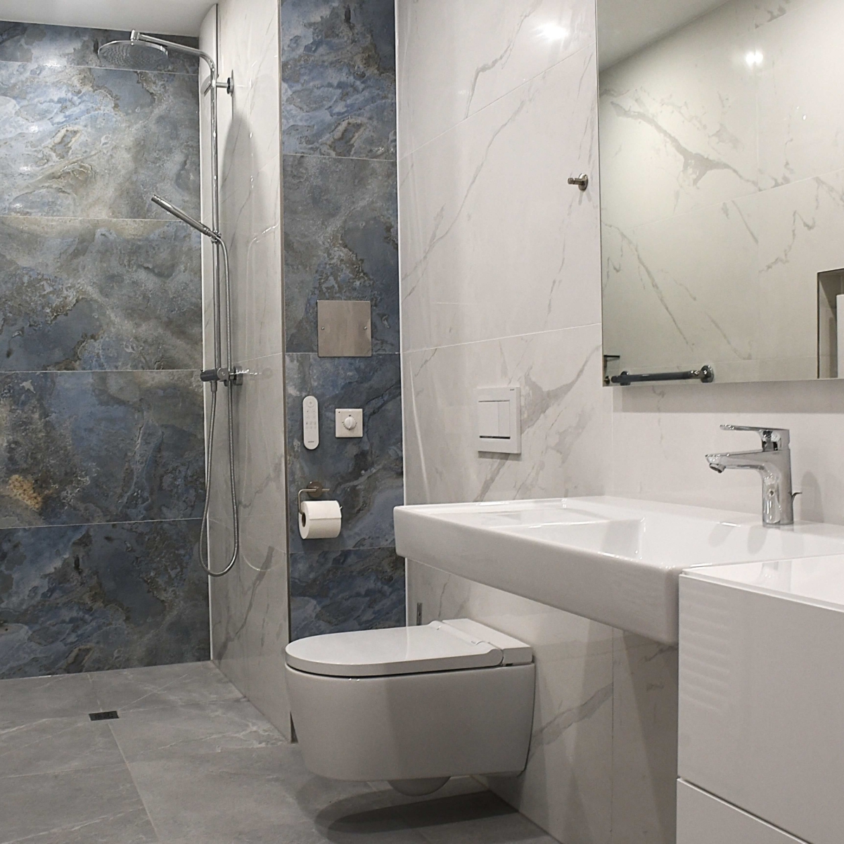 Modernes Geberit Dusch-WC vor blauen Naturstein-Fliesen: Hygiene-Upgrade und fachgerechte Montage durch EMA Installationen in 1230 Wien. 